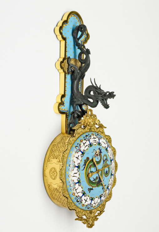 Une pendule fait en bronze, ornée avec un dragon et des caractères chinoises.